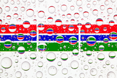 Flags  of Gambia behind a glass covered with raindrops.の写真素材