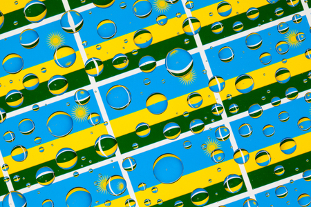 Flags  of Rwanda, behind a glass covered with rain drops.Pattern from Rwanda flags. 3D illustrationの写真素材