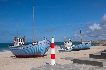 Stenbjerg,Denmark-August 15,2018: Fishing boats on the beach. Stenbjerg is a fishing village on the former island of Thy in the northwest of Jutland. It is noted for its small white fishermens huts next to the sandy beach.のeditorial素材