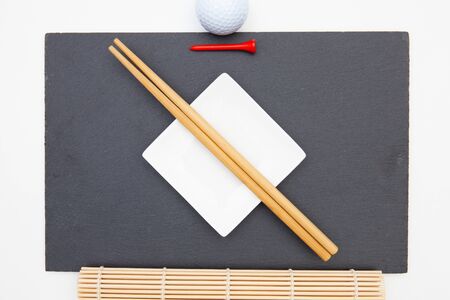 Rectangular slate plate with chopsticks for sushi and golf tee.  Golf Designの写真素材