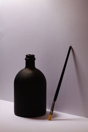 Still life with luxury black glass of Rrum and paintbrush in artist atelier.の写真素材
