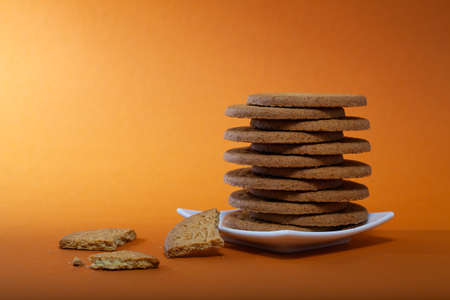 Big round of hard cheese with knife on the slate desk in the dark background.の写真素材