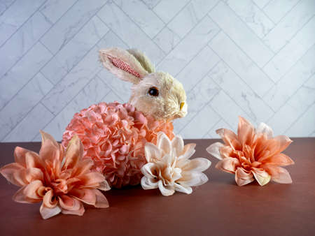 Stuffed Easter Rabbit Bunny covered in peach flowers sitting on a terra-cotta counter with a...