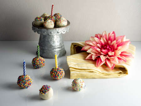 Birthday cake balls, truffle dessert, decorated with white coating and colorful sprinkles, delicious...