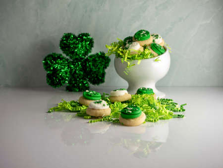 St Patrickâs Day holiday frosted sugar cookies with green and white frosting and sprinkles with four leaf clover shamrocks for a festive sweet treat.の写真素材