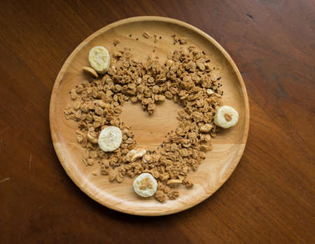 ranola in the wooden place with heart shape empty space in the middle
