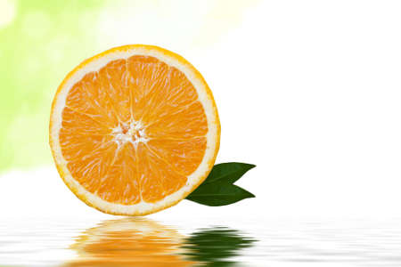 rodaja de naranja sobre fondo blanco con hojas verdes