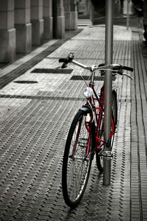 old bicycle parked on the sidewalkの写真素材