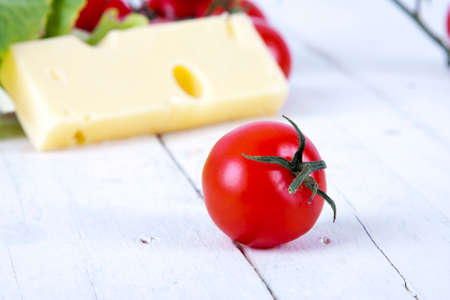 fresh and ripe tomatoes in the foreground with plant foodsの写真素材