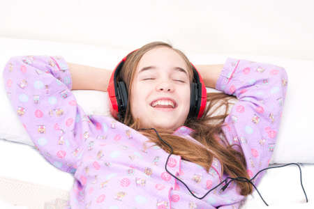 Teen girl listening music in the roomの写真素材