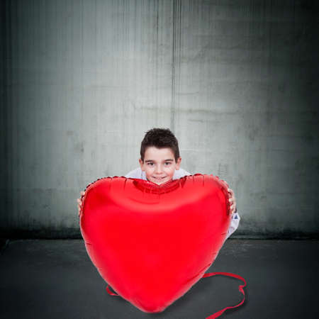 boy with heart balloon with big shirt with tieの写真素材