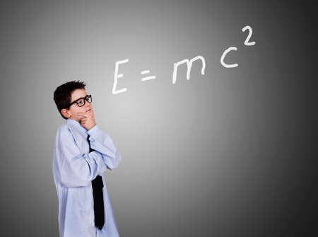 Thoughtful child in clothing business in front of blackboard with formula