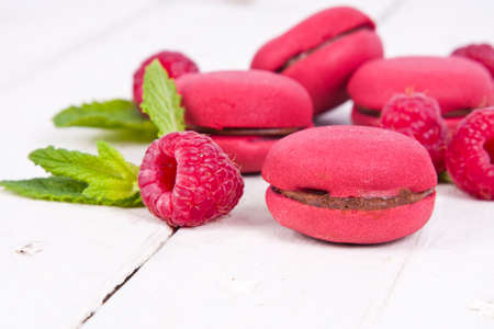 macaroons fresh raspberries on white wooden background の写真素材