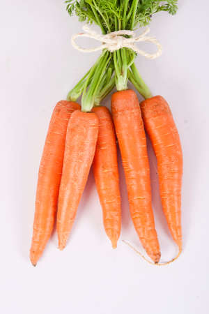 stacked fresh carrots on white background, vegetablesの写真素材