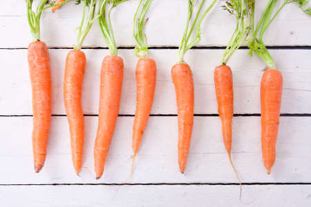 stacked fresh carrots on white background, vegetablesの写真素材