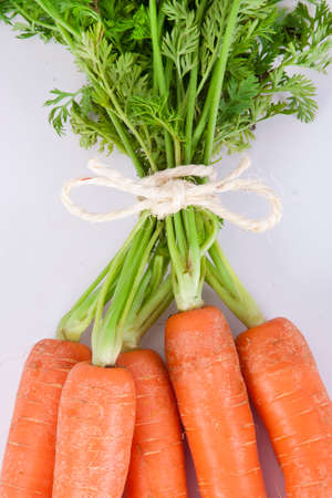 stacked fresh carrots on white background, vegetablesの写真素材