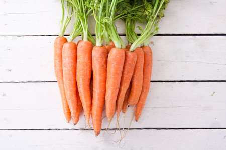 stacked fresh carrots on white background, vegetablesの写真素材