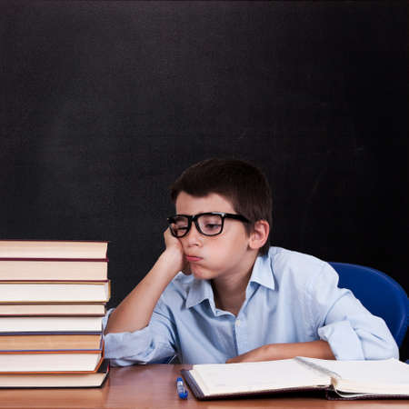 child at the table with books from school