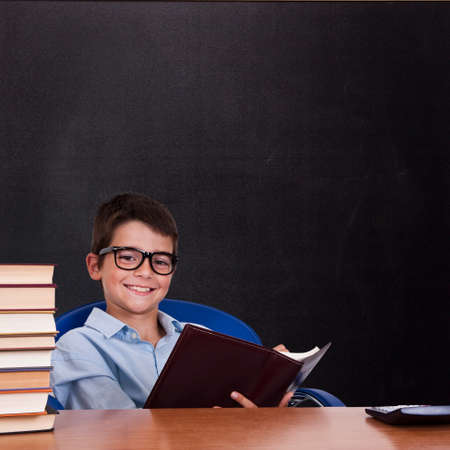 child at the table with books from school