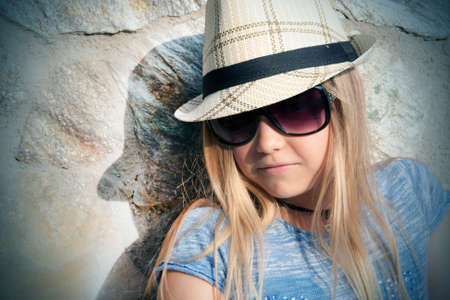 Long-haired girl in hat and sunglasses, portraitの写真素材