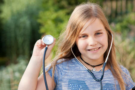 portrait of little girl with stethoscope in handの写真素材