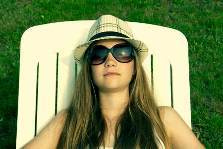 caucasian young girl sunbathing in hammock rentalの写真素材