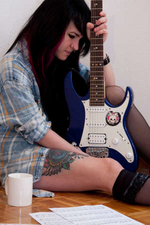 Girl playing guitar indoors, lifestyleの写真素材