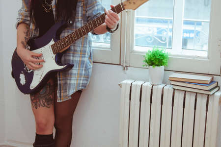 Girl playing guitar indoors, lifestyleの写真素材