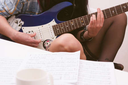 Girl playing guitar indoors, lifestyleの写真素材