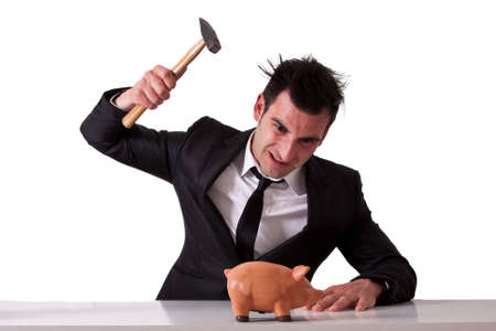 Business man breaking piggy bankの写真素材
