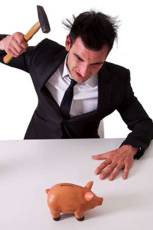 Business man breaking piggy bankの写真素材