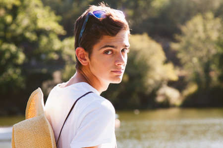 teenage boy with hat in the riverの写真素材