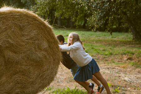 children with ball of straw on the fieldの写真素材
