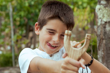 boy with slingshot outdoorsの写真素材