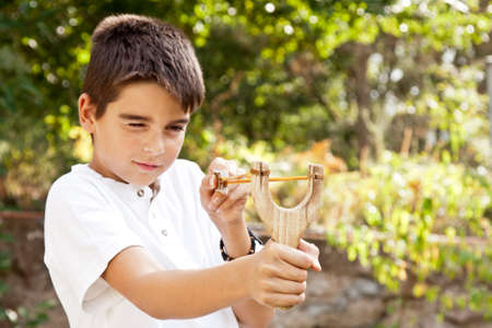boy with slingshot outdoorsの写真素材