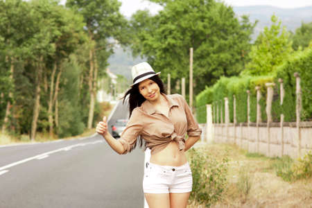 girl hitchhiking on the roadの写真素材
