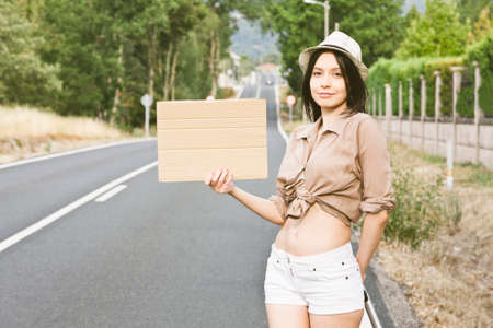 girl hitchhiking on the roadの写真素材