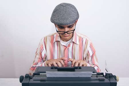 man typing on antique typewriter