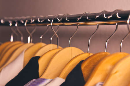 coat rack with clothes on hangers hangingの写真素材