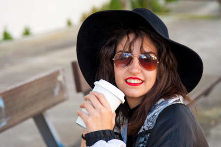 fashion girl drinking coffee on the streetの写真素材