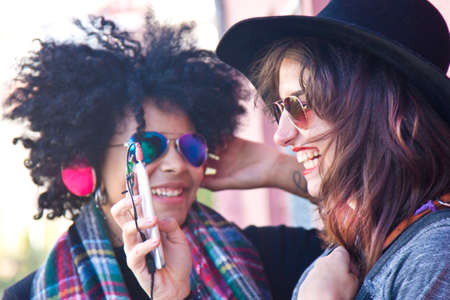 girls on the street with the phone and musicの写真素材