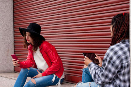 friends with mobile phone on the streetの写真素材