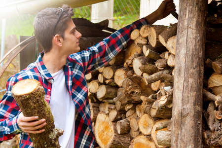 young guy with firewoodの写真素材