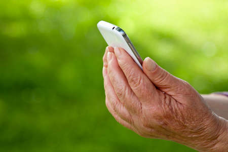 senior hands with mobile phoneの写真素材
