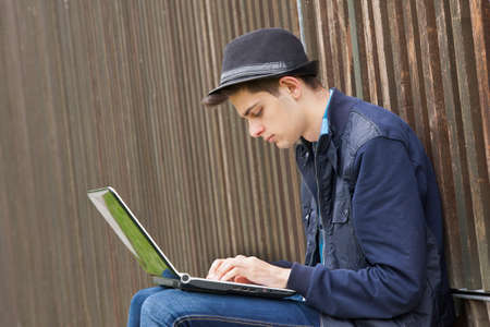 young man with laptop outdoorsの写真素材