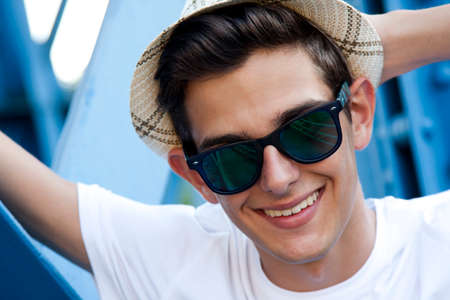 close-up portrait of young man with hat smilingの写真素材