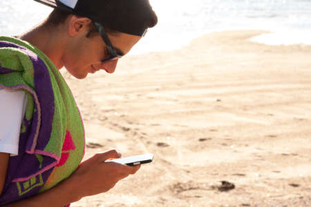 boy with the phone on the beach