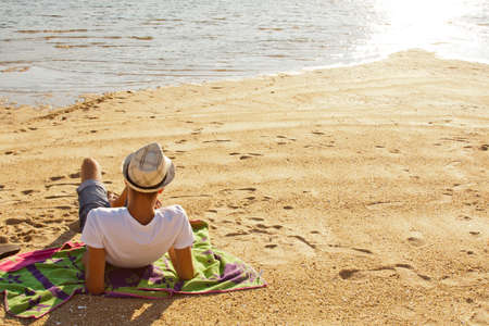 young man lying on the beachの写真素材