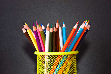 pen with colored pencils on black backgroundの写真素材