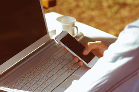 hands with mobile phone and computer